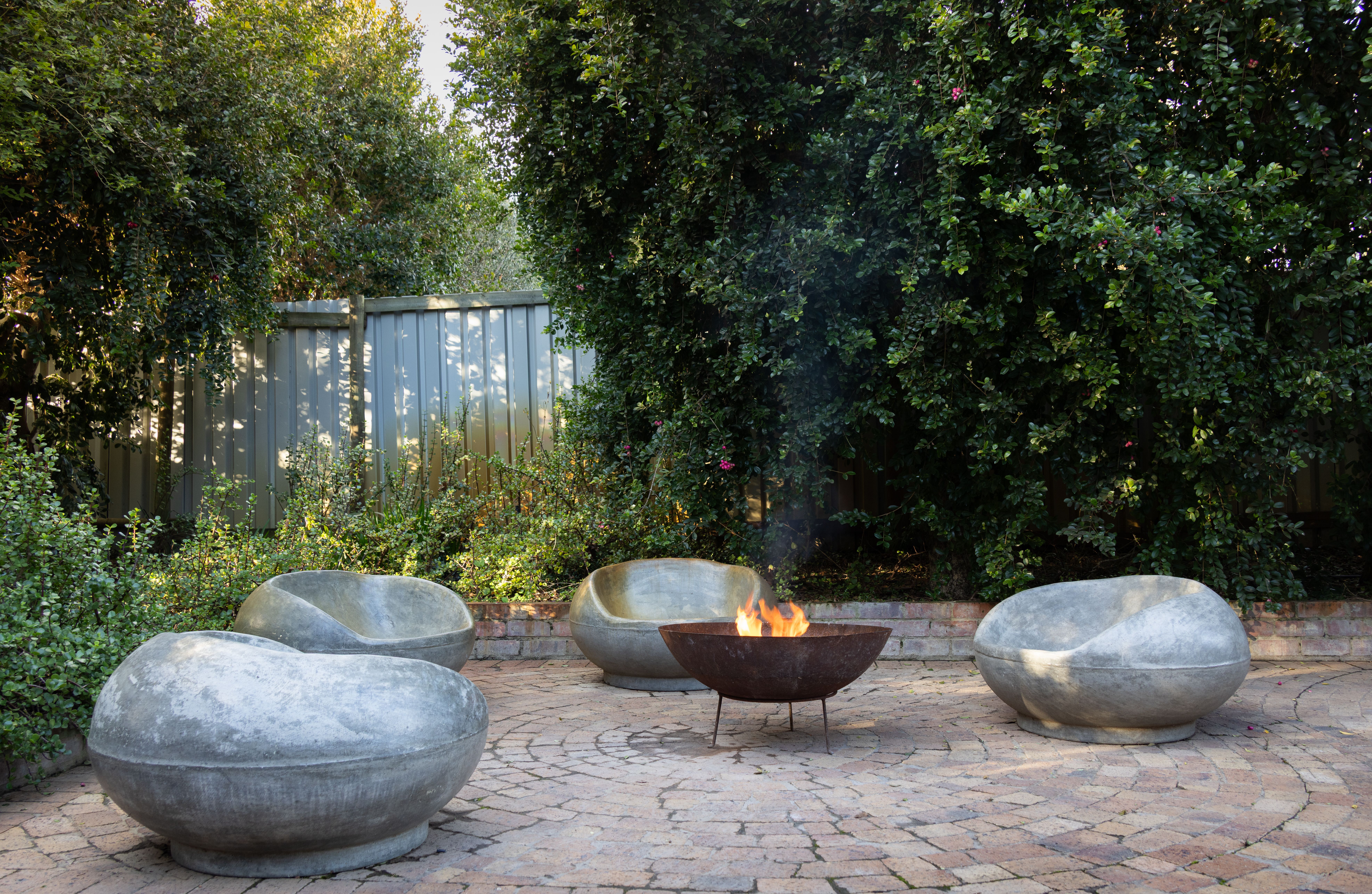Weather-resistant stone seating surrounding a modern outdoor fire pit